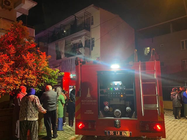 İzmir itfaiyesi ve halk, gece olay yerinde yangın söndürme çalışması yapıyor.